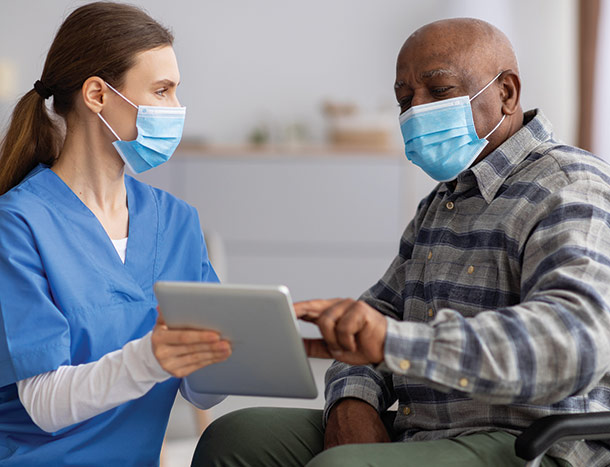 Nurse or doctor with elderly man