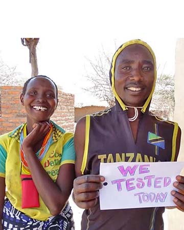 Two African boys pose with a sign