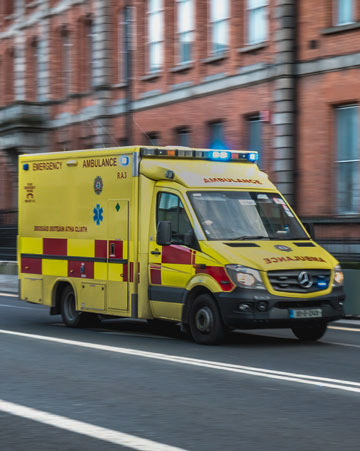Irish ambulance driving fast on the streets of Dublin on a winter day
