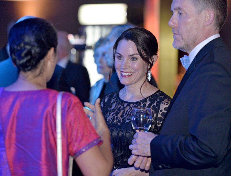 Two people converse at a lavish event