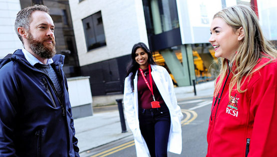 Three students converge outside a university