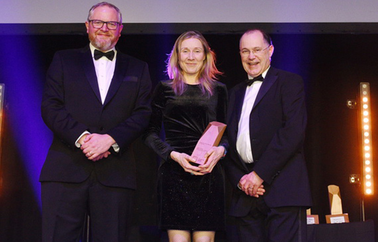 Three individuals wearing black tie, pictured at an awards event
