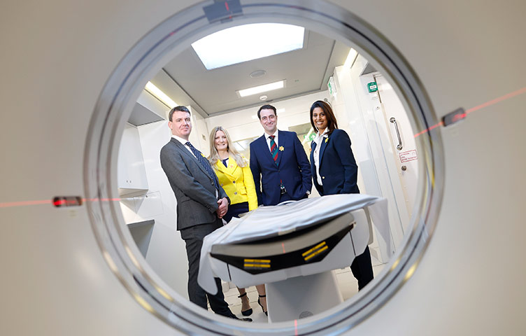 Four people are pictured in front of an MRI machine, they are Professor Daniel Ryan, Averil Power, Professor Patrick Redmond and Professor Jarushka Naidoo.