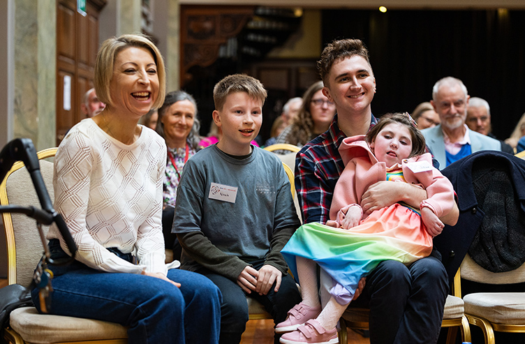 Four individuals, including two children, are pictured smiling while attending an event in RCSI Dublin