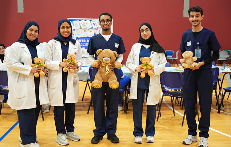 Five RCSI Bahrain Medical students hold teddy bears as they participate in the Teddy Bear Hospital.