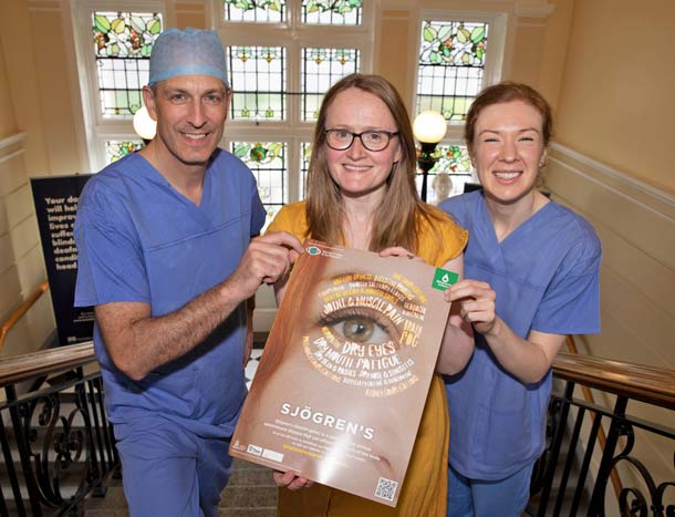 Three medical professionals pose with a brochure