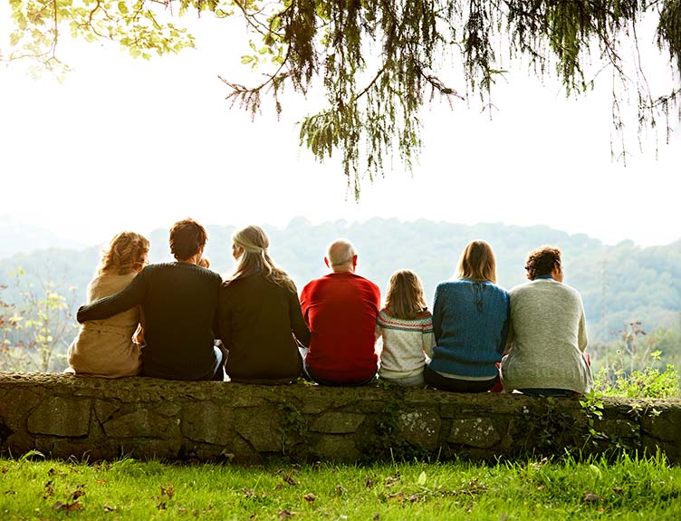 People sitting on a wall looking at scenery