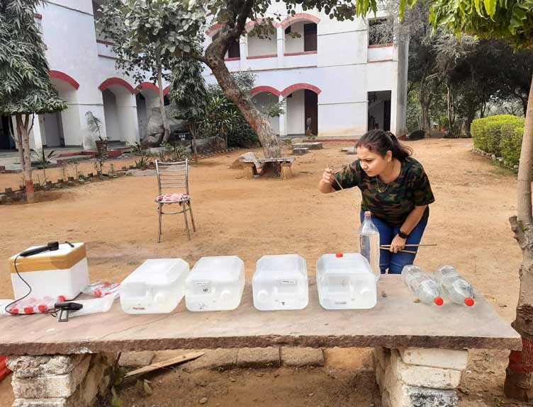 Clean drinking water Woman compares the rates of solar disinfection using two prototype designs