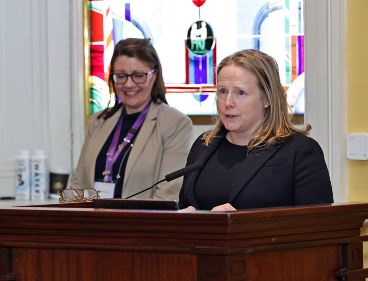 A woman speaks at a launch in an old building