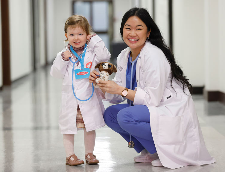 Student and child pose with smiles during Teddy Bear Hospital