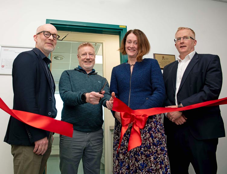 IPSC lab opening Four people celebrate at a ribbon cutting event