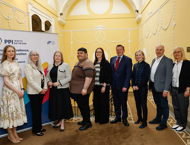 Nine people pose in a line together, in front of a pull up sign for the PPI Ignite Network in 123 St Stephen's Green