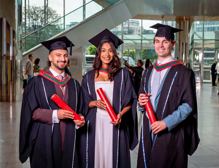 Three graduands hold scrolls at The CCD after the RCSI School of Medicine Conferring