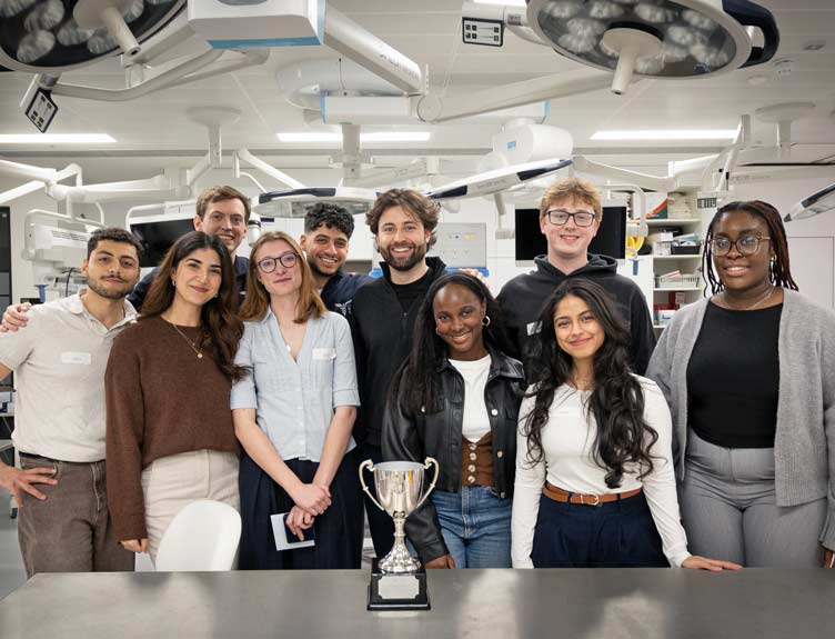 Large group of surgical students pictured with trophy