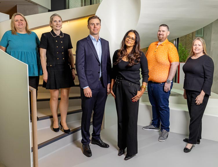 Six speakers from the MyHealth RCSI Travelling for Surgery video pose beside staircase