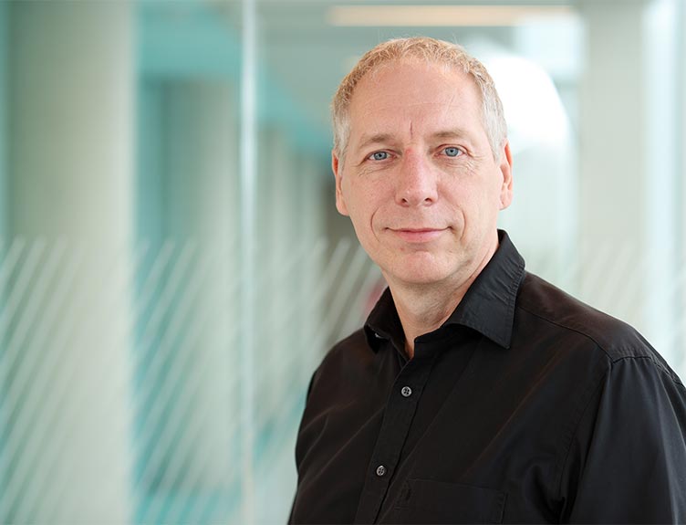 Image of Professor Andreas Heise standing in a hallway