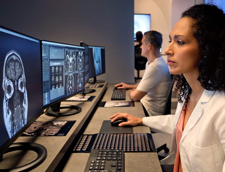 Side view of mature female radiologist working on computer while sitting in hospital.