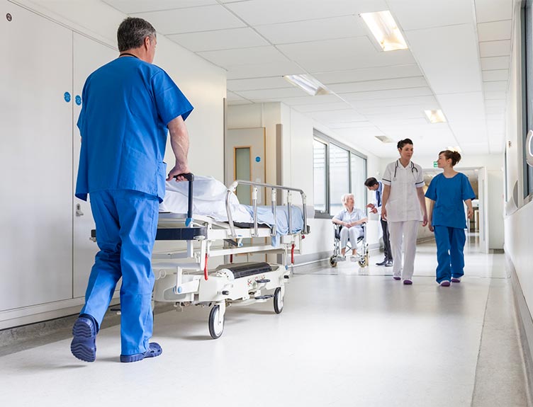 Hospital staff walking and pushing trolley