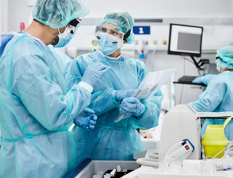 Two medical staff in protective equipment talking