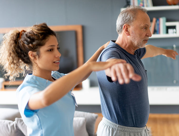 Person demonstrating balance and mobility exercises with a healthcare professional in a home setting.