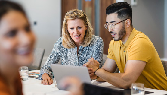 Two users study on a laptop together