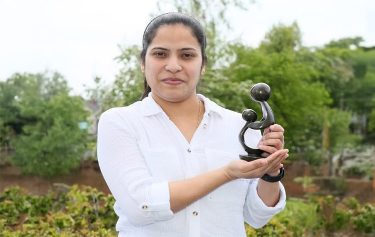 DAISY Award honouree Sajitha Abraham holds a trophy aloft