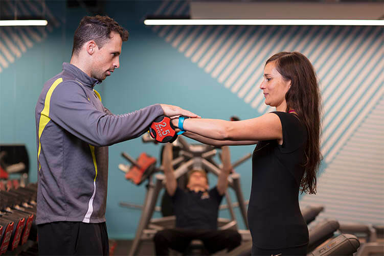 Personal trainer assisting student