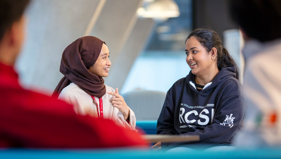 Two students converse within friendly setting