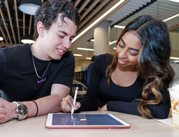 Two students study together on tablet in university