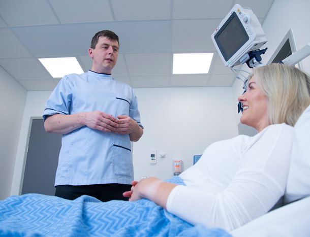 Nurse talking to patient in hospital bed
