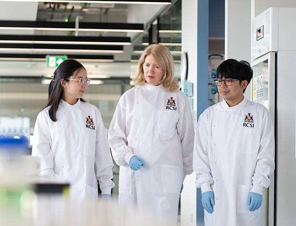 Two RCSI Postgraduate students with an RCSI researcher
