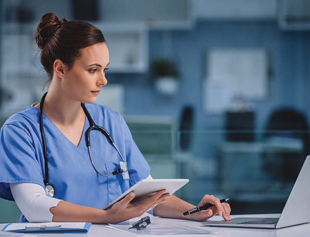 Doctor working on laptop and tablet
