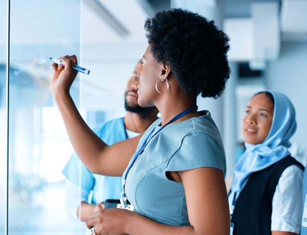Group watch tutor write on a whiteboard