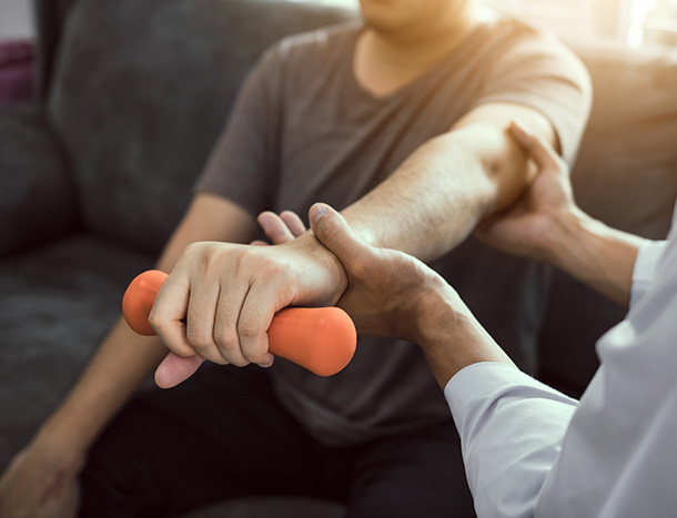 A physio treating a male patient's arm.