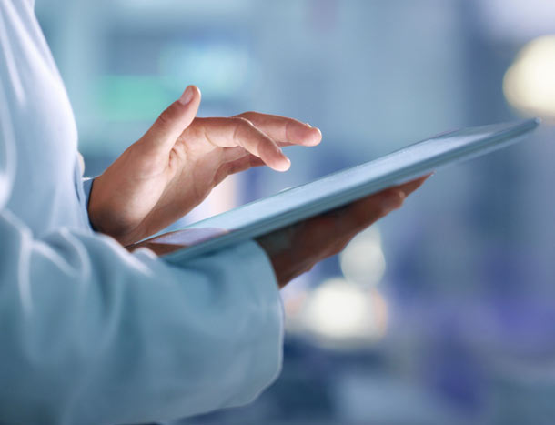 Doctor browsing the internet on a tablet for information while working at a lab