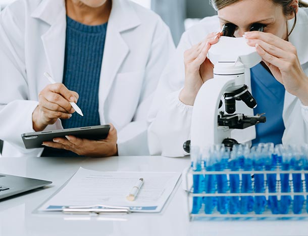 Two scientists with a microscope.
