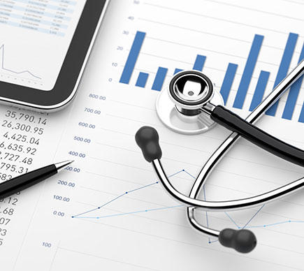 A doctor's stethoscope resting on top of printed financial data., and alongside a tablet device with a visible spreadsheet.