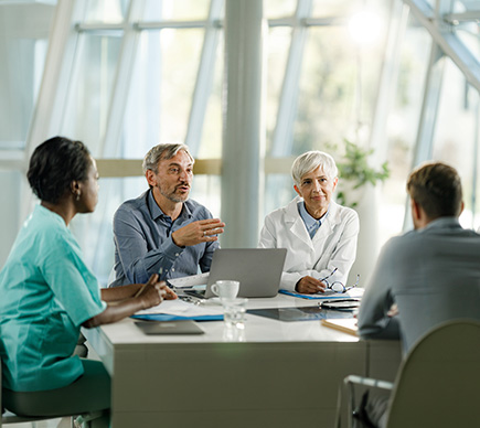 Medical professionals conferring at the conference table.