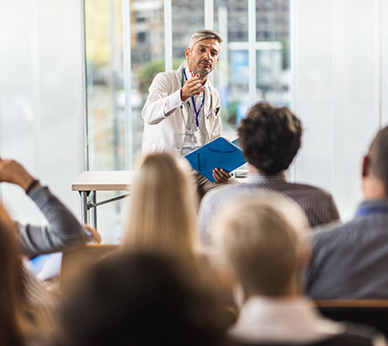A male doctor addressing a classroom.
