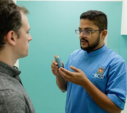 A nurse demonstrating how to use an inhaler.