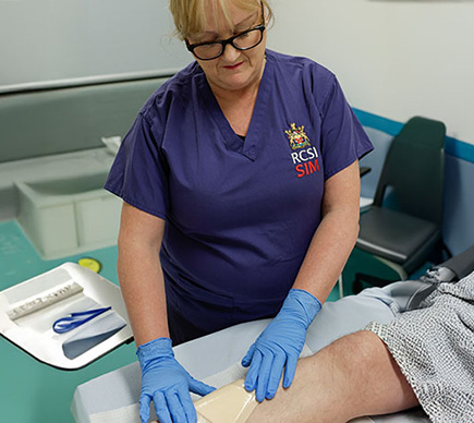 A nurse treating a leg wound.