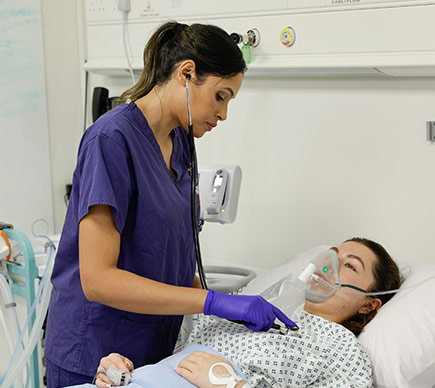 A healthcare professional cares for a patient in a hospital bed, providing support and monitoring in a clinical setting.