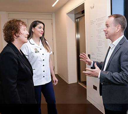 Senior nurses in conversation in a hospital corridor.