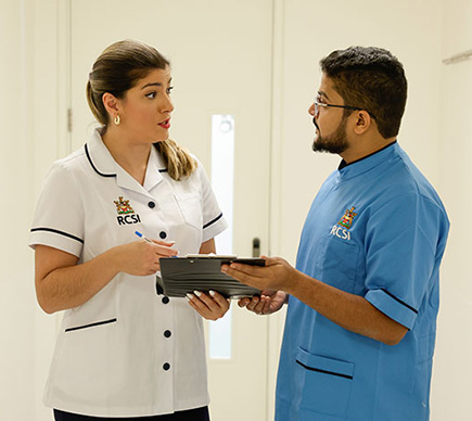 Two nurses examining a patient's chart.