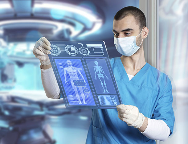 A clinician examining a scan, with medical equipment in the background.