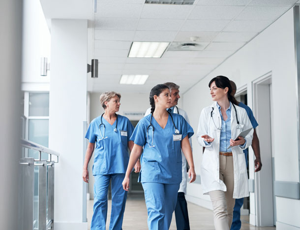 A team of medical professionals walking in a hospital corridor.