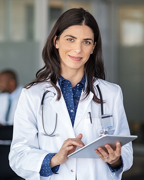 A doctor wearing white coat with stethoscope and tablet device.