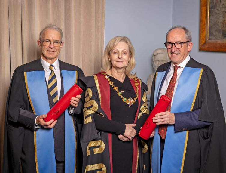 Three healthcare professionals in gowns 