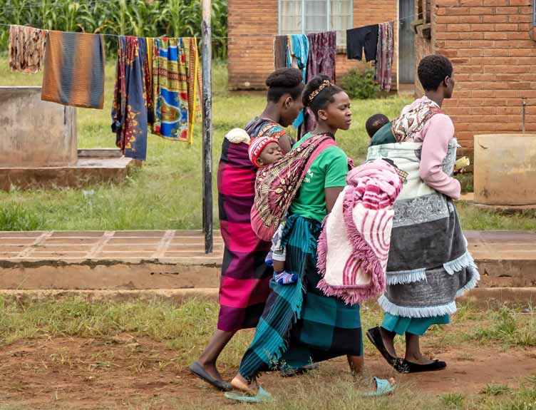 A group of women carry babies and water in Malawi