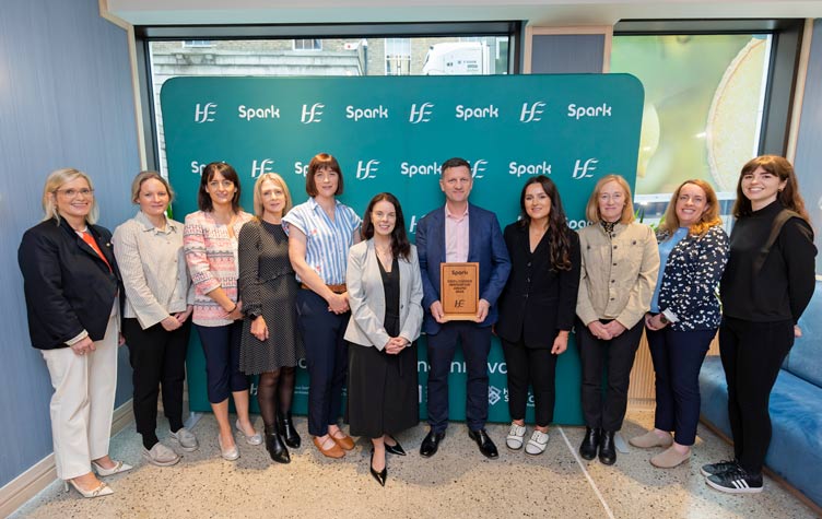 Eleven people stand in front of a teal backdrop with repeated HSE and Spark logos, while one person holds a wooden plaque reading 'Spark CEO’s Choice Innovation Award 2026'.